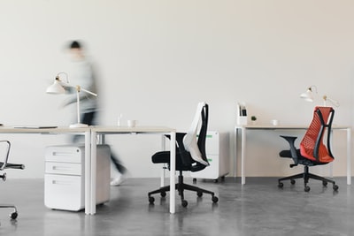 穿着白色长袖衬衫的女人坐在黑色的办公椅上